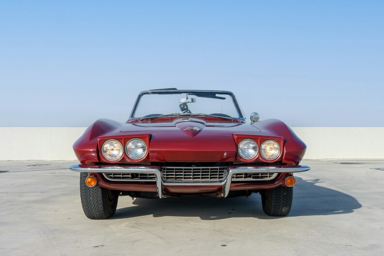 A candy apple red, 1965 Chevrolet Corvette Stingray photographed from the front.