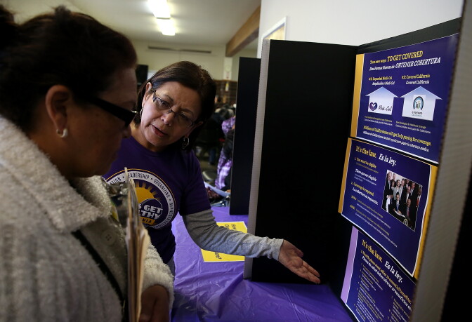 A worker explains the process for registering during a healthcare enrollment fair at the Bay Area Rescue Mission on March 31, 2014 in Richmond, California. SEIU-United Healthcare Workers West (SEIU-UHW) held the fair to help people sign up for free and low-cost health coverage through Medi-Cal or Covered California on the final day before the sign-up deadline.