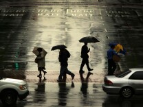 File: People walk in the rain downtown as a late-season Pacific storm brings rain and snow to Southern California April 20, 2007 in Los Angeles.