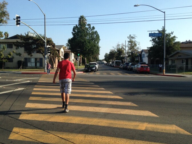 Pedestrians cross La Palma Avenue at Anna Drive in Anaheim. A police-involved shooting on Anna Drive several years ago led to violent protests in this city, where some say is divided into richer and poorer areas.