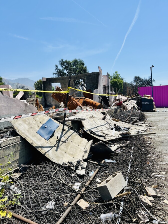 A broken wall atop a chain link fence.