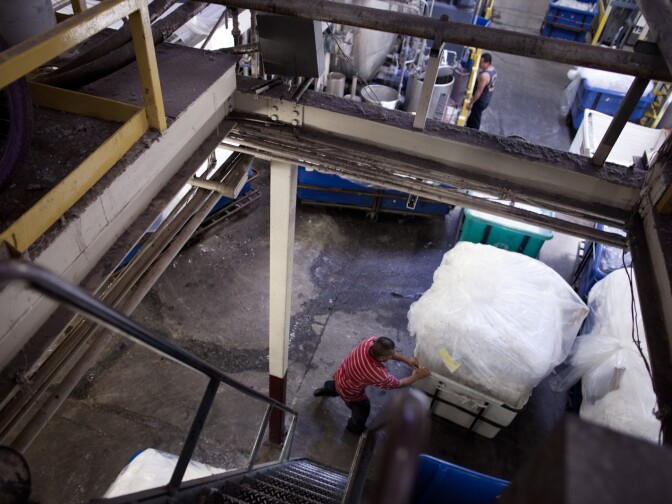 A worker moves finished fabrics at the Antex Corporation warehouse, which has operated in Los Angeles since 1973 and own Youth Monument.