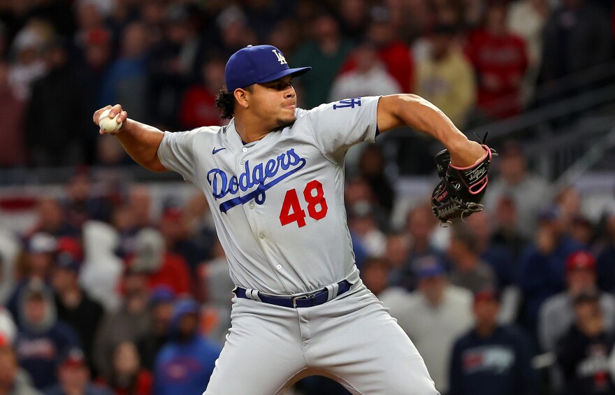 Pitcher wearing a Dodgers uniform with the number 48 prepared to pitch with his right arm back behind him.