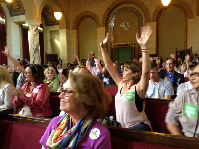 Supporters of Airbnb and home-sharing applaud after hearing testimony from a colleague