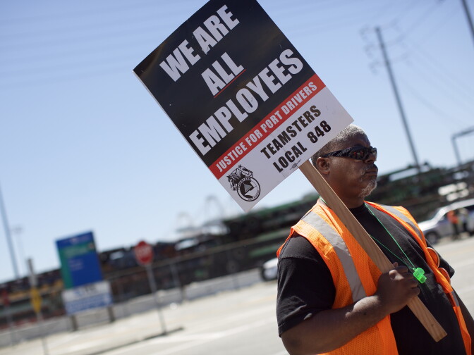 Arthur Bryson, a bus driver who is part of Teamsters Local 848, pickets at Pier J in the Port of Long Beach on Monday morning, April 27, 2015. Independent truckers for four companies have gone on strike, asking the four employers to reclassify them as permanent employees so that they can join the Teamsters union.