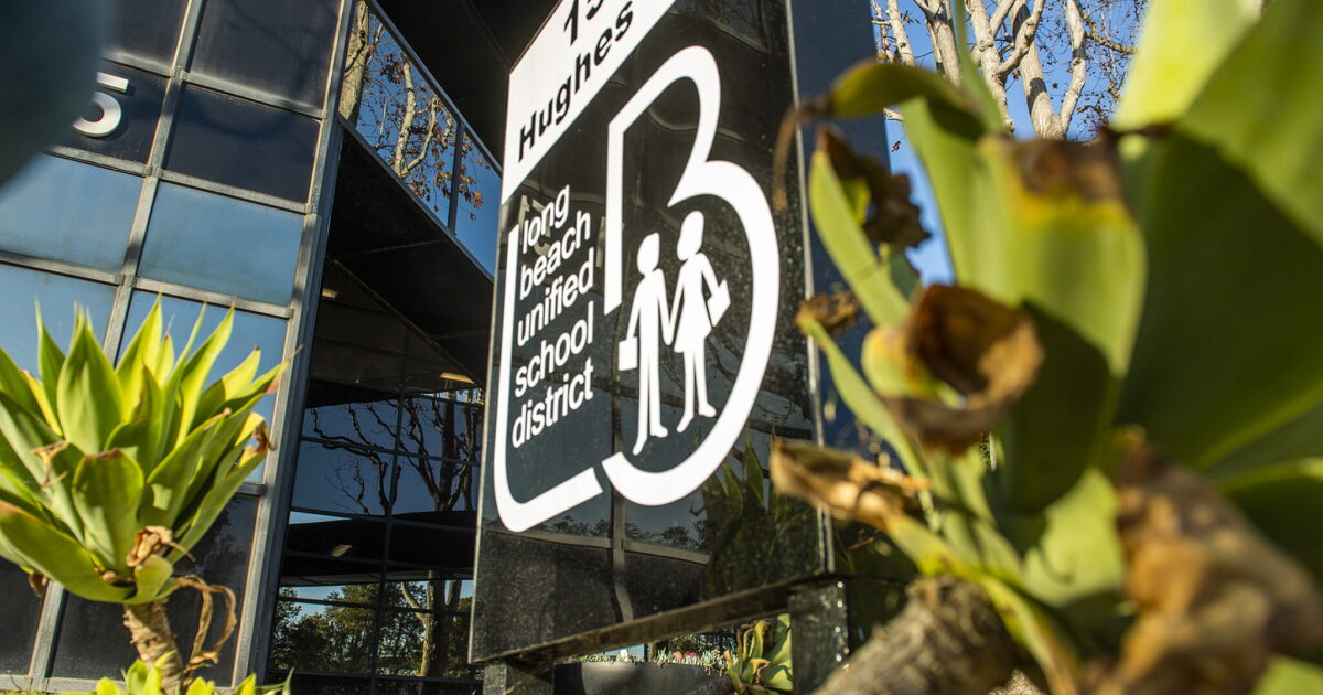 Long Beach Unified School District sign with a white “B” logo and two children holding hands.