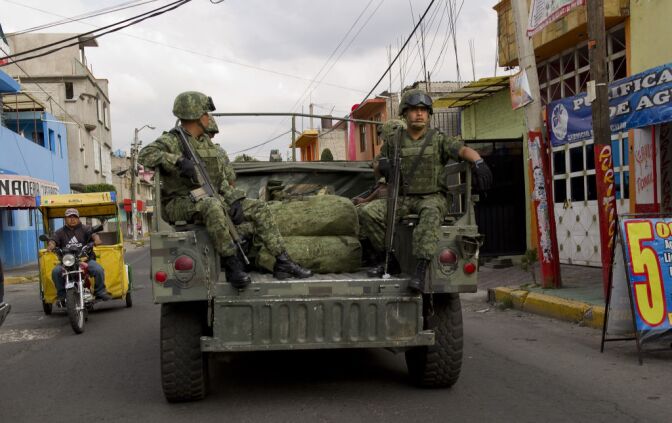 Mexican soldiers patrol along Sor Juana Avenue in Nezahualcoyotl, State of Mexico, Mexico on September 20, 2012. In the last two months the violence in Mexico raised 14 percet. More than 50.000 people have been killed in rising drug-related violence in Mexico since December 2006, when President Felipe Calderon deployed soldiers and federal police to take on organized crime.