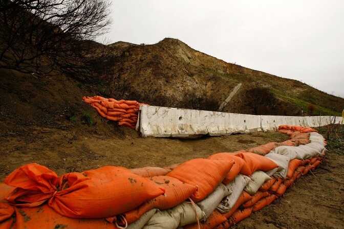 MALIBU, CA - JANUARY 4:  Sandbags and barriers have been placed to protect property from flash floods, mudslides, and debris flows that could result from rain falling on hills that were denuded by a series of firestorms that swept across southern California in October, January 4, 2008 in Malibu, California. After drought conditions and a record-dry year that lead to the wildfires, a series of storms is blowing into the region with the promise of some relief from the drought. The Corral Fire in Malibu was one of a dozen major fires that burned across more a half-million acres killing at least nine and destroying more than 2,000 homes. It was the second major series of wildfires to hit Southern California in four years.  (Photo by David McNew/Getty Images)