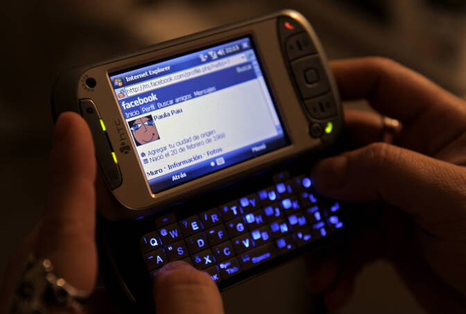 A woman uses her smart phone to acces Facebook, in Buenos Aires on March 15, 2012. The addiction to internet and social networks is increasingly becoming one of the most important reasons for consultation for addictions in health care centres in the country.   