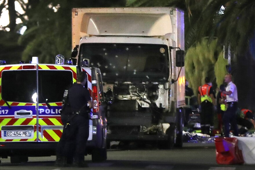 Police officers stand near a truck, with its windscreen riddled with bullets, that ploughed into a crowd leaving a fireworks display in the French Riviera town of Nice on July 14, 2016.
At least 60 people were killed when a truck ploughed into a crowd watching a Bastille Day fireworks display in the southern French resort of Nice, prosecutors said early on July 15. Nice prosecutor Jean-Michel Pretre said the truck drove two kilometres (1.3 miles) through a large crowd that was watching the fireworks.
 / AFP / VALERY HACHE        (Photo credit should read VALERY HACHE/AFP/Getty Images)