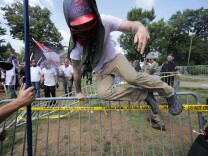 CHARLOTTESVILLE, VA - AUGUST 12:  White nationalists, neo-Nazis and members of the "alt-right" leap over barricades inside Lee Park during the "Unite the Right" rally August 12, 2017 in Charlottesville, Virginia. After clashes with anti-fascist protesters and police the rally was declared an unlawful gathering and people were forced out of Lee Park, where a statue of Confederate General Robert E. Lee is slated to be removed.  (Photo by Chip Somodevilla/Getty Images)