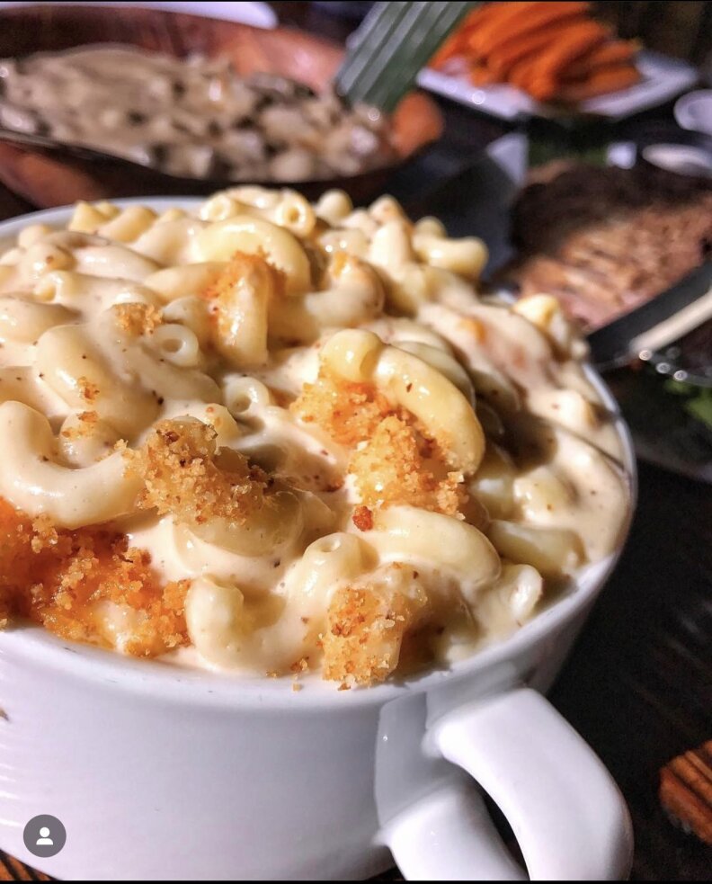 A close up of bowl of mac n cheese, scattered with browned breadcrumbs