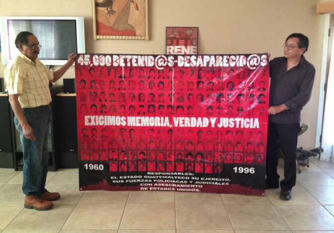 Mario Avila, left, and Eduardo Estrada hold up a banner memorializing Guatemala's wartime "desaparecidos," people who disappeared during the country's 36-year civil war. They and others were planning to caravan to the Riverside sentencing of accused Guatemalan war criminal Jorge Sosa, who was convicted on immigration fraud charges and faces eventual deportation.