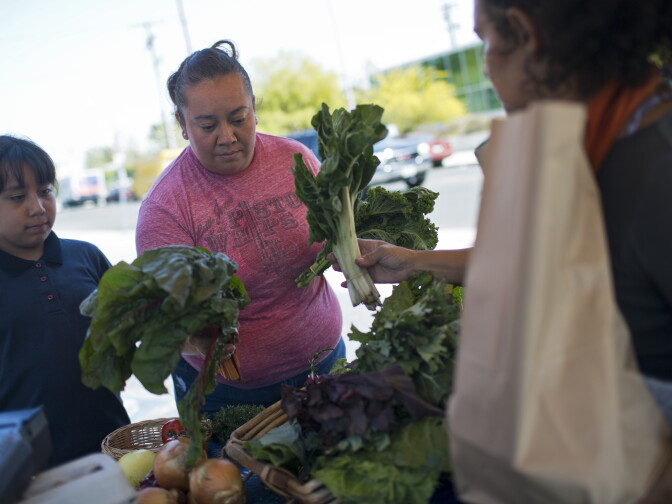 Mary Muñoz, right, and her daughter, Melanie Muñoz, shop for fresh produce at Community Services Unlimited's Village Market Place in South Los Angeles on Friday, April 10, 2015. The produce stand is in the parking lot at Century Market every Friday from 2 to 5 p.m.