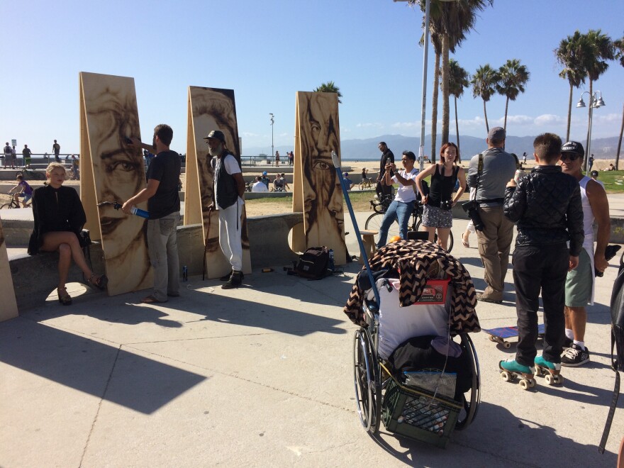 A crowd gathers on the Venice Boardwalk to watch Aronson paint. He regularly works at art walks and other live outdoor events around Los Angeles.