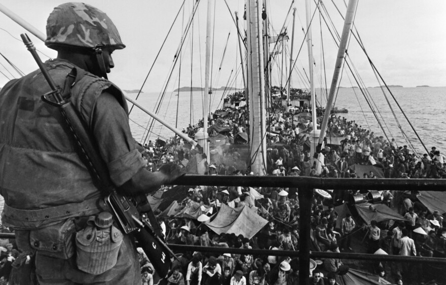 A picture released on May 05, 1975 shows an GI watching South Vietnamese refugees crowding a US Navy boat off the coasts of Vietnam at the end of Vietnamese war. AFP PHOTO        (Photo credit should read -/AFP/Getty Images)