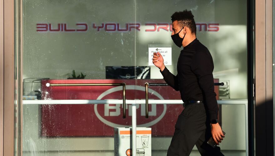 A man wearing a facemask walks past the BYD office in Los Angeles, California on May 13, 2020. - US authorities this month denied initial regulatory approval for N95 masks from BYD Co., a Chinese company that had secured huge orders for the protective gear including a $1 billion deal with the state of California. (Photo by Frederic J. BROWN / AFP) (Photo by FREDERIC J. BROWN/AFP via Getty Images)