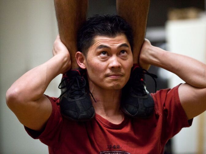 Man Tran, a chiropractic acupuncturist with a martial arts background, holds a standing dancer in a trick called a "full stack." Tran hired the group for his wedding three years ago, then decided to join.