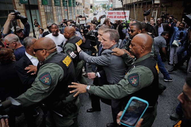 BALTIMORE, MD - MAY 23:  Baltimore City Sheriff's Deputies surround and protect Baltimore Police Officer Edward Nero's family members as demonstrators and members of the news media crowd around outside the Mitchell Courthouse-West after Nero was found not guilty on all charges against him related to the arrest and death of Freddie Gray May 23, 2016 in Baltimore, Maryland. One of six police officers charged, Nero was found not guilty by Baltimore Circuit Judge Barry Williams in a bench trial.  (Photo by Chip Somodevilla/Getty Images)