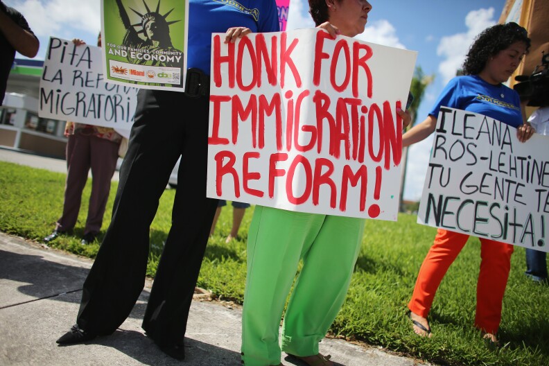 Protesters stand together as they hold a protest to ask their congress people to make immigration reform a reality on August 16, 2013 in Miami, Florida.