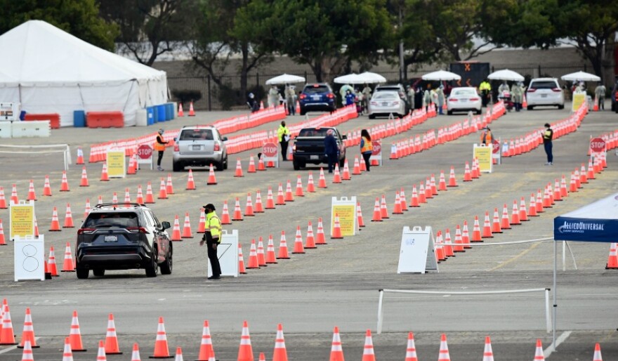 An image of a parking lot that is full of cones and cars in line to receive COVID-19 vaccines.