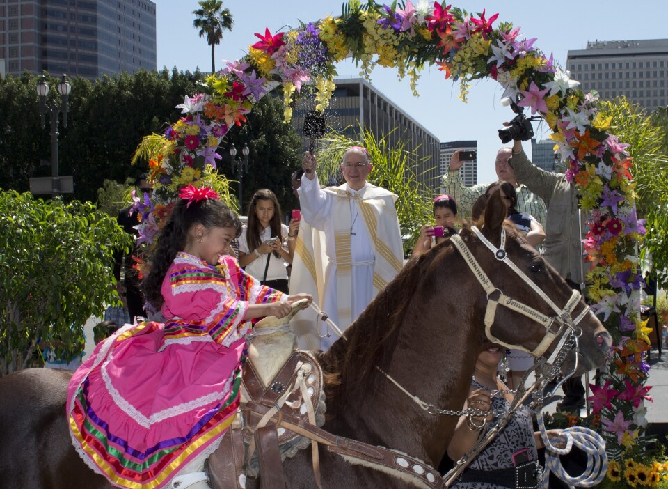 Anaii Gutierrez, 4, and her horse, Cara de Chango, receive a holy water blessing from Catholic Archbishop Jose H. Gomez during a Blessing of Animals Easter event in Los Angeles, California on April 4, 2015.