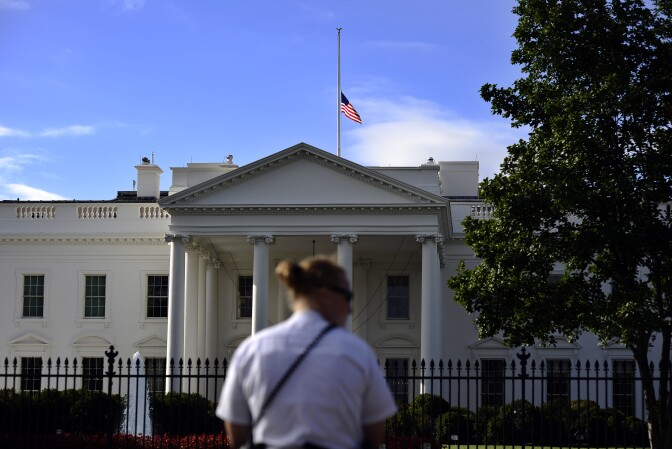 A member of the US Secret Service Uniform Division guards as the national flag flies half-mast on the roof of the White House on September 17, 2013 a day after deadly Navy Yard shooting in Washington, DC. Investigators on Tuesday tried to piece together what led a former US Navy reservist to open fire at a Washington base, killing 12 people before being gunned down by police. Police identified the gunman as Aaron Alexis of Fort Worth, Texas, who served in the Navy from 2007 to 2011 before becoming a defense subcontractor for computer giant Hewlett-Packard.