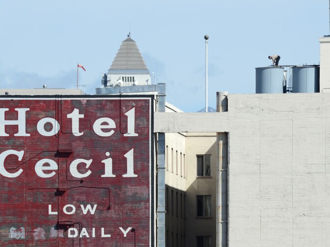 A worker stands on a water tank on the roof of the Hotel Cecil in Los Angeles, California on February 20, 2013. The body of 21-year-old Canadian tourist Elisa Lam was found in a water tank on the roof of the hotel three weeks after she went missing.