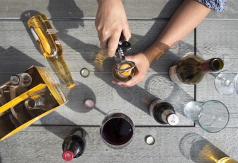 An array of beer bottles sit on a picnic table.