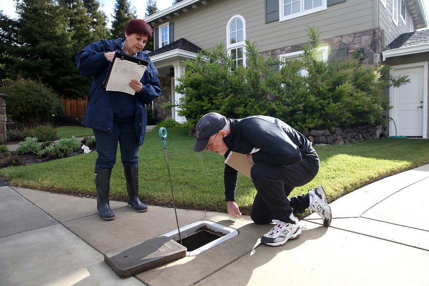WALNUT CREEK, CA - APRIL 07:  East Bay Municipal Utility District (EBMUD) water conservation technician Rachel Garza (L)  inspects a water meter with home owner Michael Shain as she performs a water conservation audit of a home on April 7, 2015 in Walnut Creek, California.  As California enters its fourth year of severe drought, EBMUD and water districts throughout the state are assisting customers with finding ways to reduce water use at their homes. California residents are facing a mandatory 25 percent reduction in water use.  (Photo by Justin Sullivan/Getty Images)