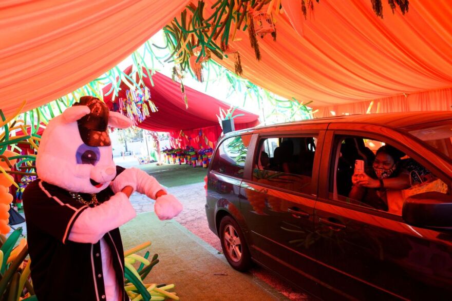 People watch as they drive through Easter themed tents after receiving kits to host their own Covid-19 pandemic safe celebrations during a drive-in Easter Eggstravaganza for children including foster youth during an event held by Guardians of Love and Los Angeles Mission on April 2, 2021 in Los Angeles, California. (Photo by Patrick T. FALLON / AFP) (Photo by PATRICK T. FALLON/AFP via Getty Images)