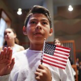 LOS ANGELES, CA - SEPTEMBER 14:  New U.S. citizen Davies Garcia, 11, originally from Mexico, holds an American flag during a naturalization ceremony conducted by U.S. Citizenship and Immigration Services (USCIS), on September 14, 2018 in Los Angeles, California. USCIS presented citizenship papers at the L.A. Public Library to around 50 young people who obtained their citizenship via their parents. Some of the young people became citizens once their immigrant parents became citizens while others were adopted by citizens of the U.S. The ceremony was part of annual Constitution Week and Citizenship Day celebrations conducted by USCIS.  (Photo by Mario Tama/Getty Images)