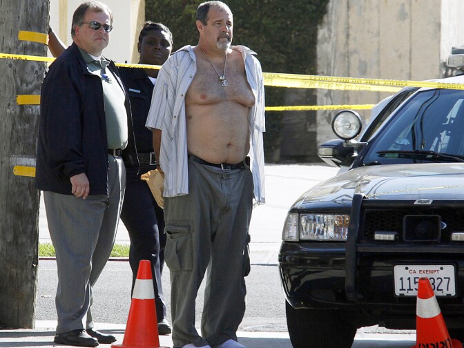 Police officers stand with Scott Evans Dekraai (with open shirt) near the Salon Meritage beauty salon in Seal Beach, Calif. on Wednesday, Oct. 12, 2011. The trial for Dekraai was rescheduled to start June 9, 2014. Dekraai is accused of killing eight people, including his ex-wife. (File photo)