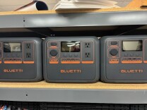 Gray portable backup power batteries on a shelf. 