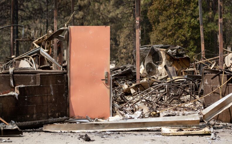 A door stands amidst the burned remains of a building.