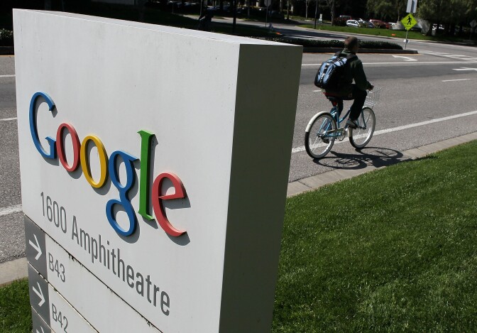 A bicyclist rides by a sign outside of the Google headquarters March 10, 2010 in Mountain View, California. Google announced today that they are adding bicycle routes to their popular Google Maps and is available in 150 U.S. cities.  