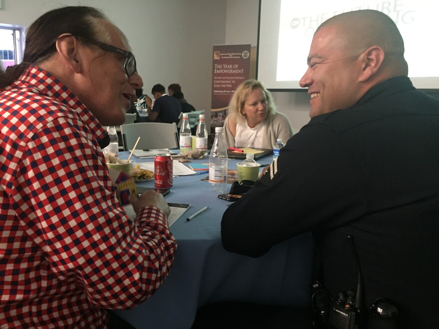 LAPD Officer Joseph Lopes talks with Carol Braddock, an artist and resident of Liemert Park, during a meeting to improve police-community relations organized by the Institute for NonViolence in Los Angeles (Wednesday, July 13, 2016).