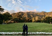 A couple, with their backs turned to the camera, look at the foothills surrounding Altadena. 