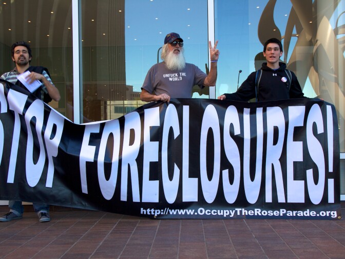 Occupy LA supporters hold up a "Stop Foreclosures!" sign outside of the BNY Mellon Bank during today's press conference.