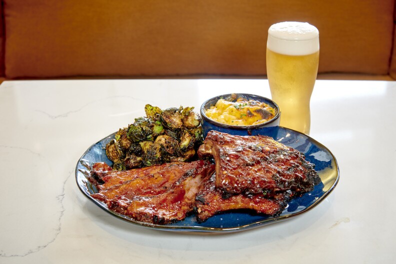 Baby Back Ribs with Charred Brussel Sprouts and Burnt Ends Mac & Cheese on a plate and a beer.