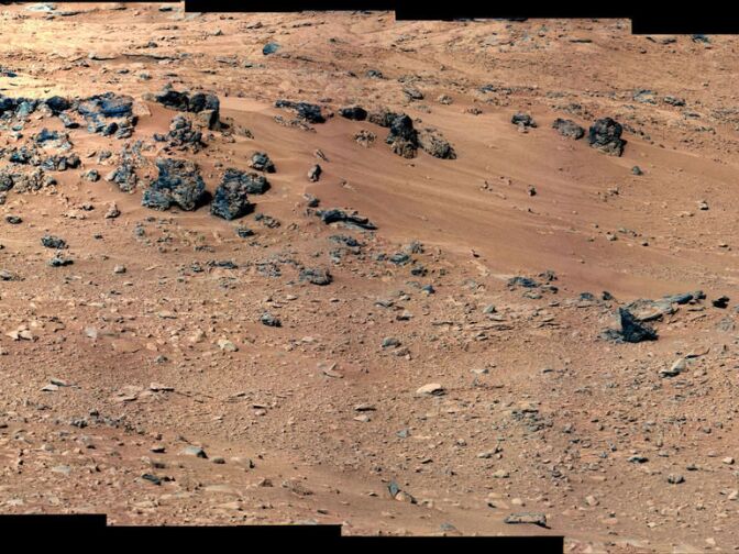 This patch of windblown sand and dust downhill from a cluster of dark rocks is the "Rocknest" site, which has been selected as the likely location for first use of the scoop on the arm of NASA's Mars rover Curiosity. 