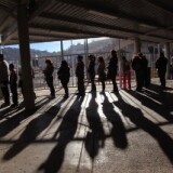 Hundreds of people wait to pass from Mexico into the United States at the border crossing on December 10, 2010 at Nogales, Arizona. Despite Arizona's tough immigration enforcement laws, thousands of Mexican citizens have permits to work in the U.S. and commute daily from their homes across the border in Mexico.