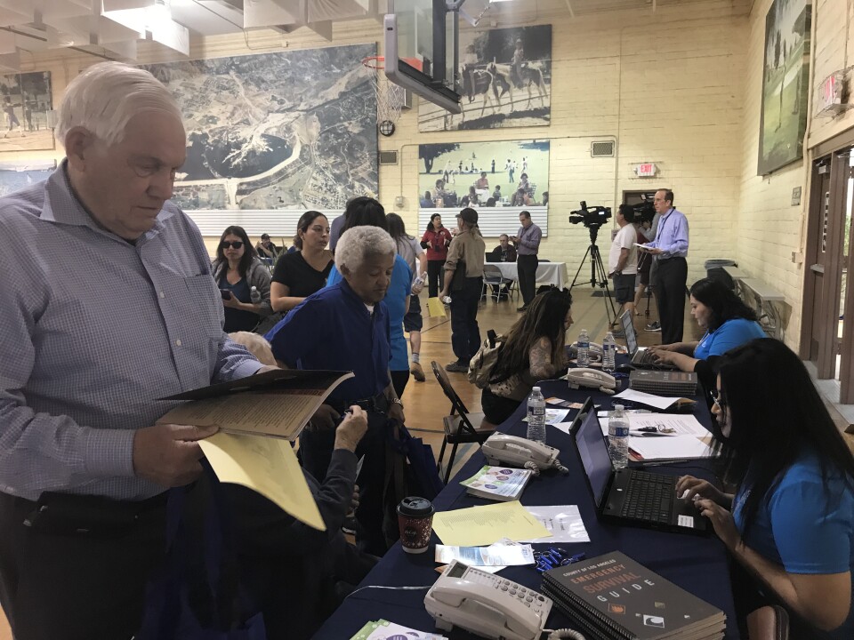 Richard Thompson (left) prepares to file a damages report at the local assistance center set up by Los Angeles city and county to assist victims of the Creek, Rye and Skirball fires. Some 60 homes, including his, burned down in the fires. 