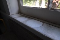 A dark layer of ash from the Eaton Fire is visible on a windowsill that held potted plants. Health officials have said this ash potentially contains lead, asbestos and arsenic. 