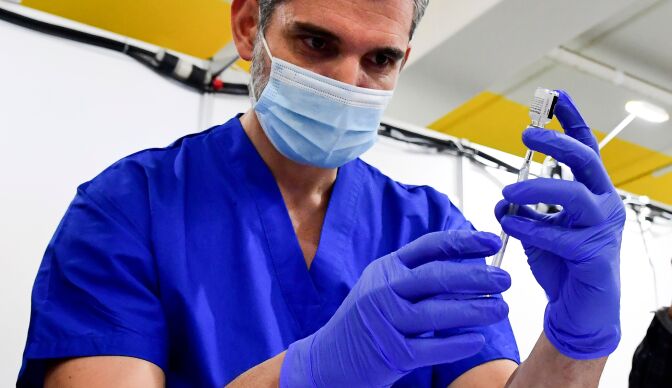 Derenik Gharibian, Area Pharmacy Drector from Kaiser Permanente, fills a syringe with the Pfizer Covid-19 vaccine in preparation for vaccinations on the opening day of a large-scale Covid-19 vaccination site at a parking structure at Cal Poly Pomona University in Pomona, California on February 5, 2021. - The Cal Poly Pomona site is one of two opening in California, with the other located at Moscone Center in San Francisco. According to organizers each site will ultimately have the capacity to administer up to 10,000 vaccine doses per day. (Photo by Frederic J. BROWN / AFP) (Photo by FREDERIC J. BROWN/AFP via Getty Images)