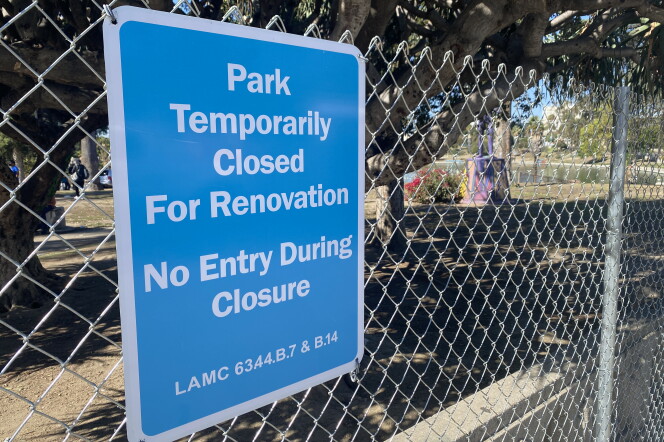 a blue sign with white letters posted to the fence surrounding the park reads: Park temporarily closed for renovation, no entry during closure.