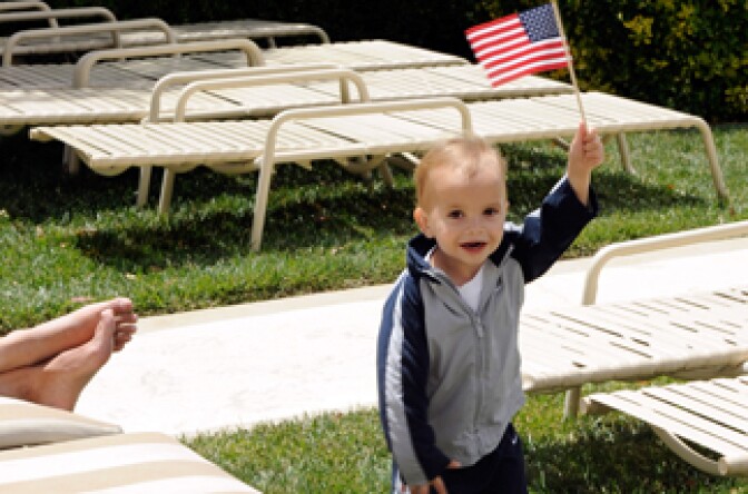 File photo: Roman Porrino, son of television personality Angel Porrino, runs holding an American flag at a Memorial Day weekend pool party at Ravella at Lake Las Vegas May 29, 2011 in Henderson, Nevada.