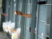 An immate uses a mirror to look outside his cell at the Los Angeles Men's Central Jail in downtown Los Angeles, 19 May 2004. 