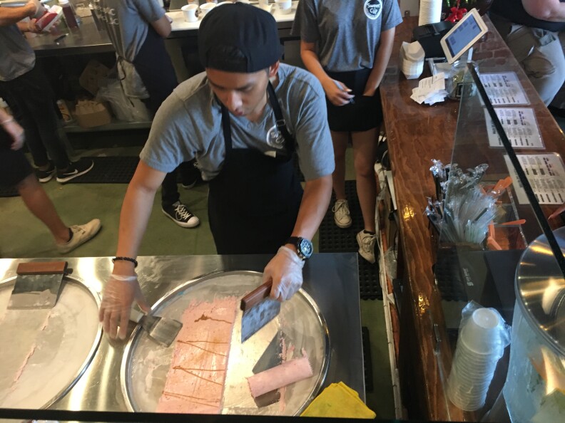 Sweet Cup worker rolls ice cream.
