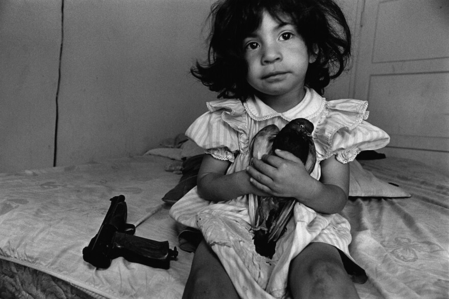 Watts, Los Angeles, 1994. Three-year-old "Esperanza" named her pet pigeon after her wheelchair-bound teenaged uncle. He was shot by a rival gang member in a drive-by shooting. 